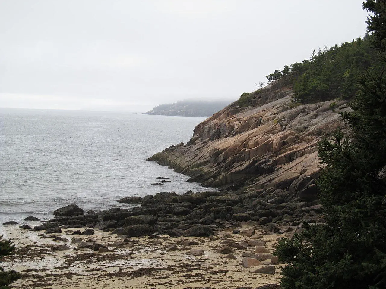 Rocky shoreline beside Sand Beach in Acadia National Park; water and trail access depend on current conditions.